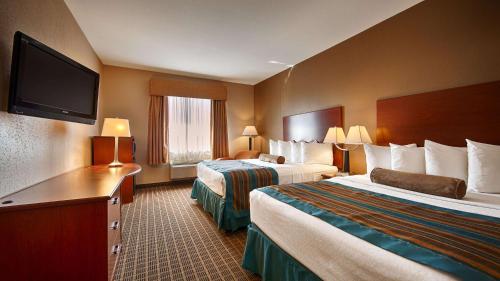 Cette chambre comprend 2 lits et une télévision à écran plat. dans l'établissement Best Western Orange Inn & Suites, à Orange