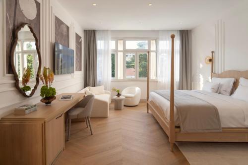 a bedroom with a bed and a desk with a mirror at Heritage Hotel Zagreb Dubrovnik in Dubrovnik