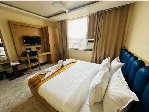 ein Hotelzimmer mit einem großen Bett und einem Fenster in der Unterkunft PS Marriott Hotel in Patna