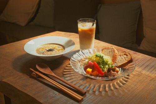 a table with a bowl of food and a glass of orange juice at Amu in Beppu