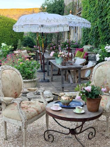a patio with tables and chairs and an umbrella at Pytts House Boutique Bed & Breakfast in Burford
