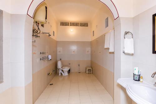 a bathroom with a toilet and a sink at Alivaa Heritage Lotwara Fort - Near Shri Mehandipur Balaji Temple in Dausa
