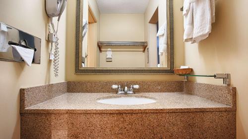 een badkamer met een wastafel en een spiegel bij Best Western West Greenwich Inn in West Greenwich