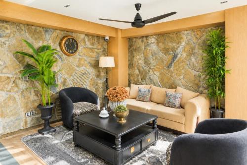 a living room with a couch and chairs and a table at SkyHouse by Ace Luxe in Islamabad