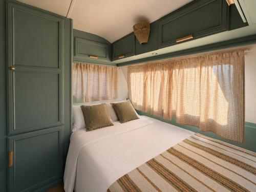 a bed in a small room with a window at Caravana Lobo Camp in Boca de Huérgano
