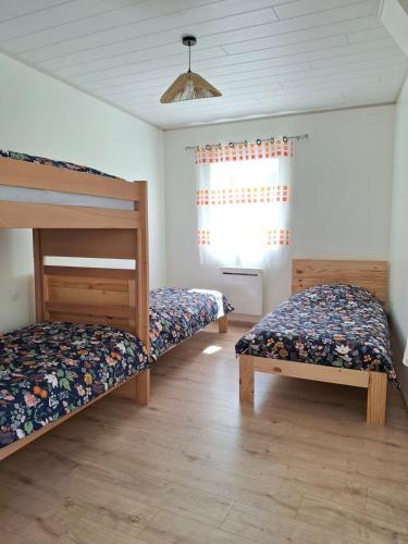 a bedroom with two bunk beds and a window at La belle étoile in Saugues