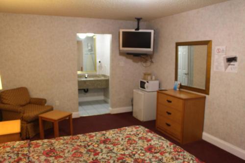 a hotel room with a bed and a television at Highlander Motor Inn Atlantic City in Galloway