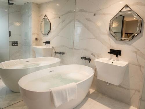 a white bathroom with two sinks and a tub at HOTEL THE MAY Jongno in Seoul