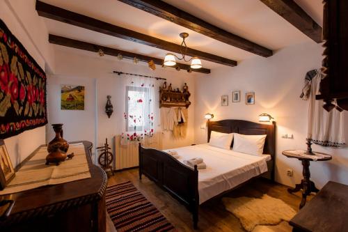 a bedroom with a bed and a table and a window at Casa cu Cerdac in Nucşoara