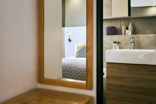 a bathroom with a mirror next to a sink at iKON Apartments in Windhoek