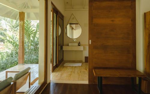 a hallway with a wooden door and a mirror at Kurulu Bay in Ahangama