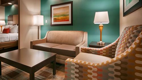 a hotel room with a couch and a bed at Best Western Plus Atrium Inn & Suites in Clarksville