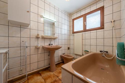 a bathroom with a tub and a toilet and a sink at Appartement 5 - La Petite Caille in Plombières-les-Bains