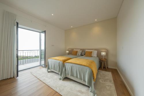a bedroom with two beds and a large window at Ponta do Pargo Village - By WeHostMadeira in Ponta do Pargo