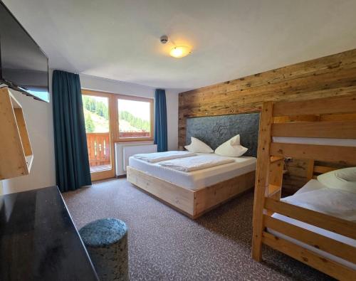 a bedroom with two bunk beds and a window at Berghotel Gerlosstein in Hainzenberg