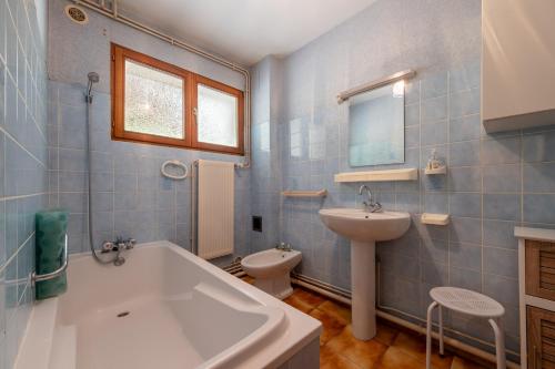 a bathroom with a tub and a toilet and a sink at La Petite Caille - Appartement 4 in Plombières-les-Bains