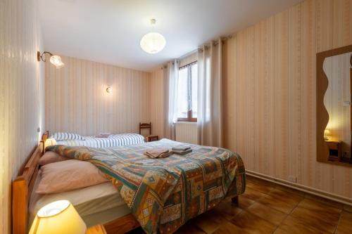 a bedroom with a bed and a window at La Petite Caille - Appartement 4 in Plombières-les-Bains