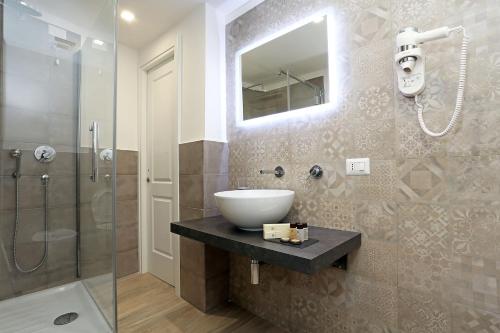 y baño con lavabo y ducha acristalada. en Capricci Romani, en Roma