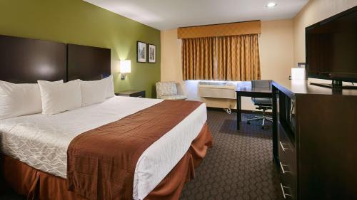 Habitación de hotel con cama grande y escritorio. en Best Western Sky Valley Inn en Monroe