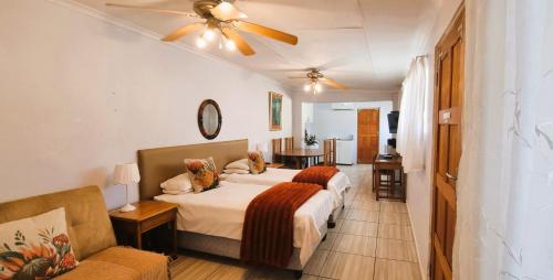 a hotel room with two beds and a couch at Protea House in Graaff-Reinet
