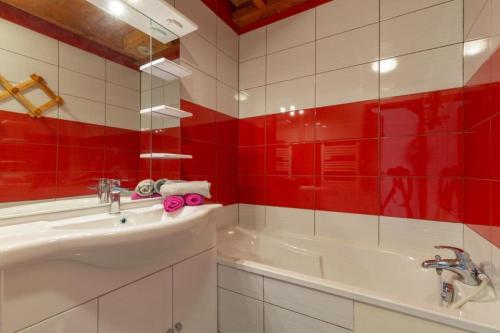 a red and white bathroom with a tub and a sink at Les Balcons de St So Appartement B in Saint-Sorlin-dʼArves
