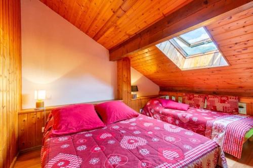 a bedroom with two beds with pink sheets and a window at Les Balcons de St So Appartement B in Saint-Sorlin-dʼArves