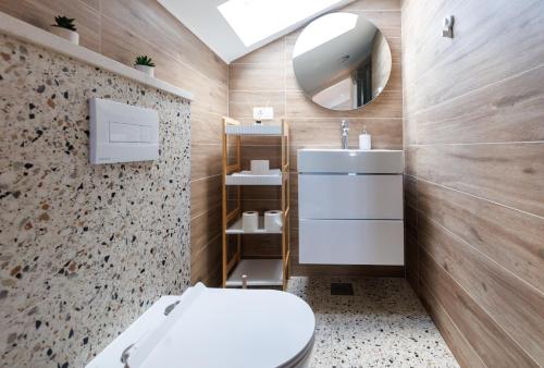 a bathroom with a white toilet and a mirror at Villa Brig in Ramljane