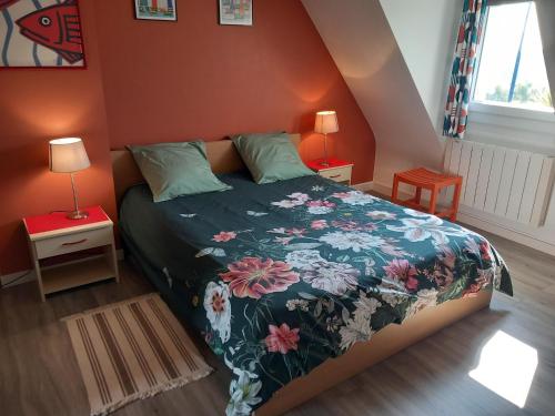 a bedroom with a bed with a floral bedspread at Bénodet Chambre D'hôtes Les Sauges in Bénodet