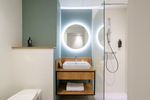 a bathroom with a sink and a shower at ibis Styles Angouleme Centre in Angoulême