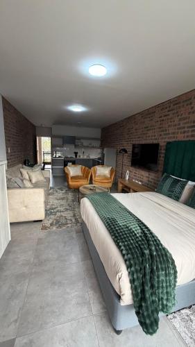 a bedroom with a large bed and a living room at CS Nest Modern Studio Athlone in Pietermaritzburg