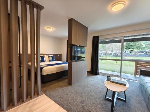 a hotel room with a bed and a couch at Hideaway of Rotorua in Rotorua