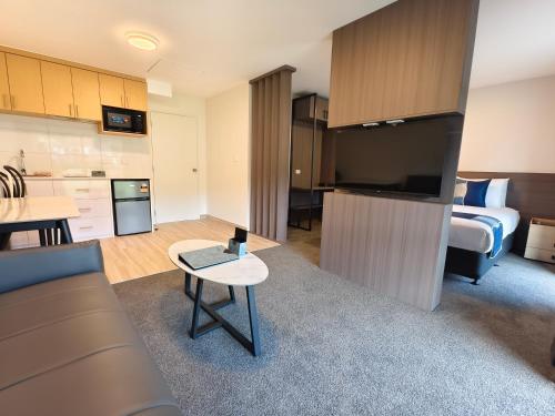 a living room and kitchen with a bed and a table at Hideaway of Rotorua in Rotorua