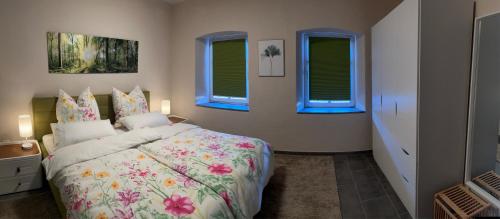 a bedroom with a bed and three windows at Natur pur Eifel in Gerolstein