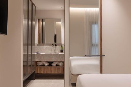 a bathroom with a sink and a mirror at Nesean Plaza Hotel in Heraklio