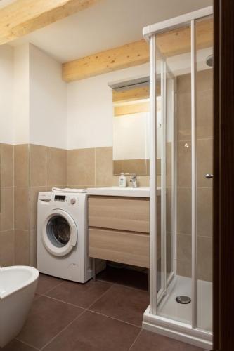 a bathroom with a washing machine and a washer at Casa Chris by AMA Val di Fassa in Pozza di Fassa