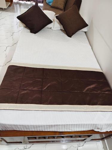 two beds with brown and white sheets and pillows at krishna madhavam in Guruvāyūr