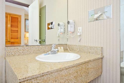 a bathroom sink with a hair dryer and a mirror at Best Western Green Bay Inn and Conference Center in Green Bay