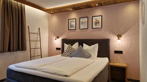 a bedroom with a bed with white sheets and pillows at Chasa Patria Apartments in Ischgl