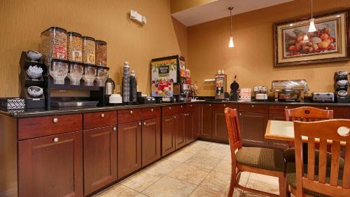 a restaurant kitchen with a counter and a table and chairs at Best Western Plus New Caney Inn & Suites in New Caney