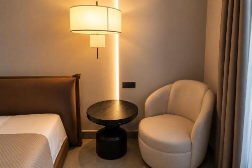 a room with a chair and a table and a lamp at Stella View in Pefki