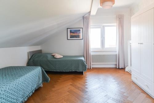 a attic bedroom with two beds and a window at Villa Laurent in Charzykowy