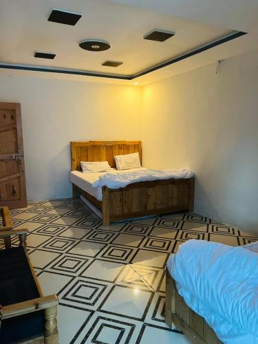 a bedroom with two beds and a tiled floor at Royal Palace in Naran