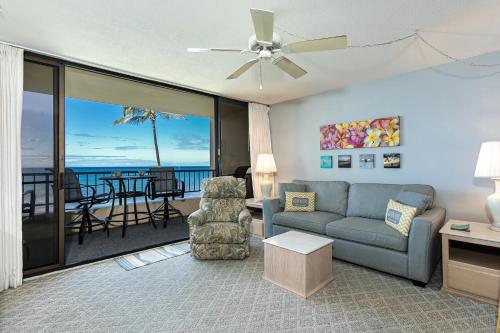 a living room with a couch and a chair and a balcony at SUGAR BEACH RESORT, #319 in Kihei