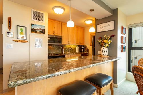 a kitchen with a counter with two stools at SUGAR BEACH RESORT #412 in Kihei