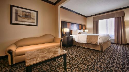 a hotel room with a bed and a couch at Best Western Plus Airport Inn & Suites in Salt Lake City