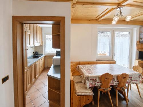 a kitchen with a table and two chairs and a table at Appartamento Cuore by AMA Val di Fassa in Campitello di Fassa