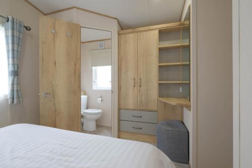 a bedroom with a white bed and a toilet at Cockerham Sands Holiday Park in Cockerham