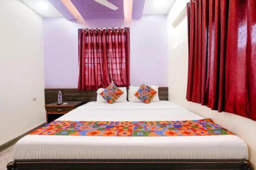 a bedroom with a bed with red curtains at Via Sagar Darshan in Panaji