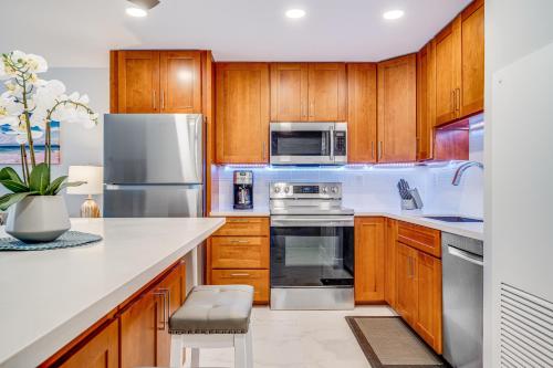 a kitchen with wooden cabinets and stainless steel appliances at SUGAR BEACH RESORT, #PH27 in Kihei