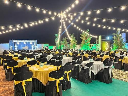a banquet hall with tables and chairs and lights at Shore Appartments in Udupi